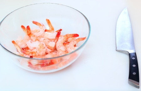 A lot of prepared tiger shrimps and knife at the deskの写真素材