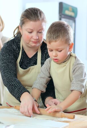 Little boy with his mother cooking at the kitchenの写真素材