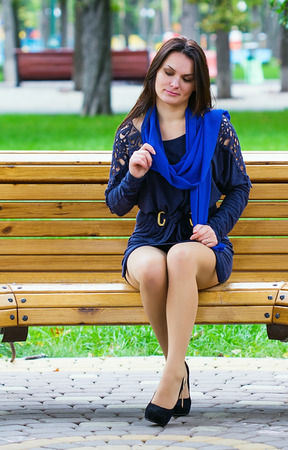 Girl sitting in the park on the benchの写真素材