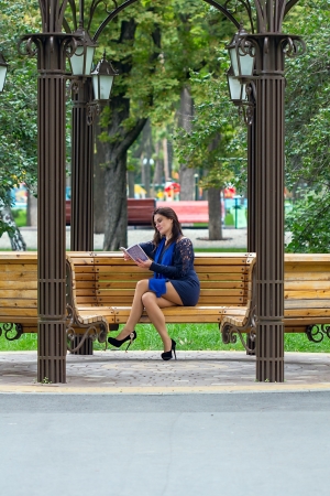 Girl reading book on the bench in parkの写真素材