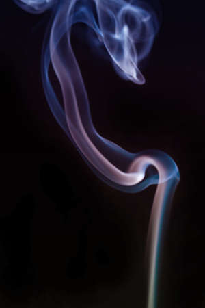 Swirling smoke from the incense on a backgroundの写真素材