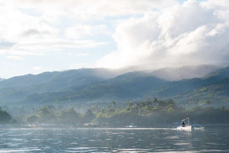 White boat fisherman in the morning mist. Indian Ocean