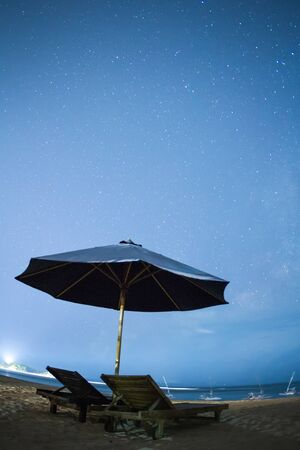Starry night on the beach with sky, beach and sun beds