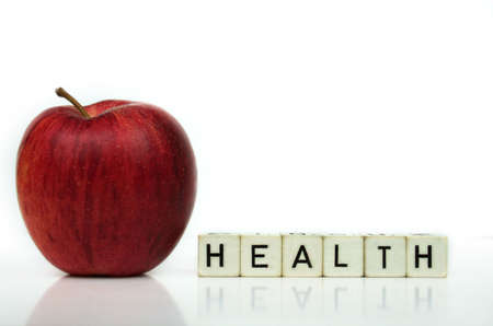 red apple and cubes with letters in front of a white background - healthcareの写真素材