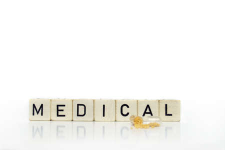 medical issue - a open pill in front of some cubes with the word medicalの写真素材