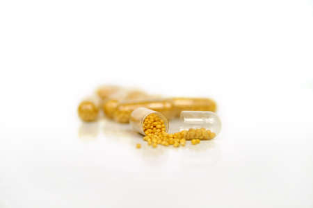 Some yellow pills on a white background - medical issueの写真素材