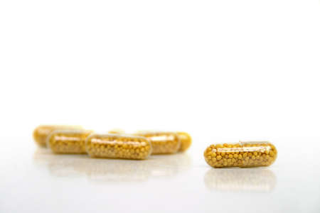 Some yellow pills on a white background - medical issueの写真素材