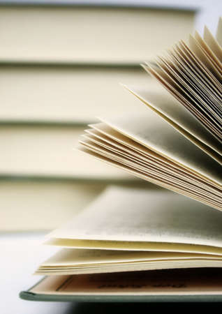 a pile of books and a open book