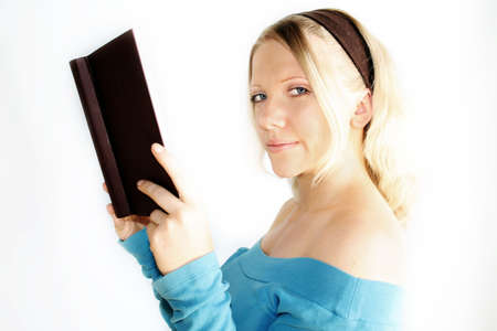 A young, blond woman is reading a book