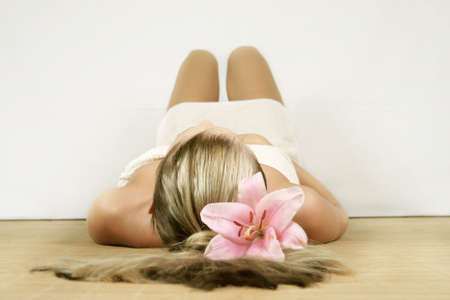 a young beautiful woman is relaxing in spa - wellness with a flowerの写真素材