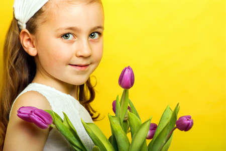 smiling beautiful young girl with tulips at spring