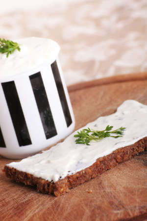 a whole-grain bread with some herbage and a cream cheeseの写真素材