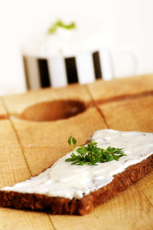 a whole-grain bread with some herbage and a cream cheeseの写真素材