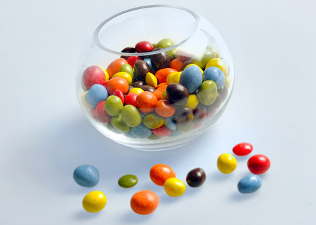 Bowl with candies on blue background の写真素材