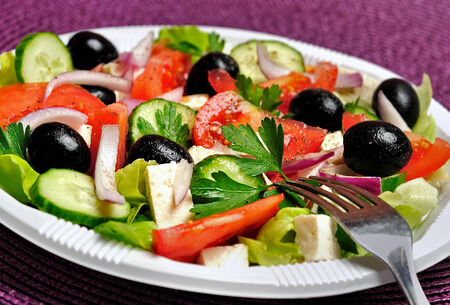 Plate with salad on purple tableの写真素材