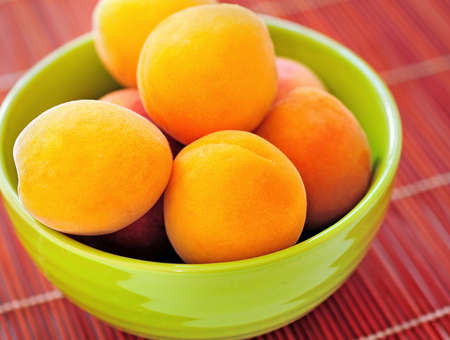 Bowl with apricot on tableの写真素材