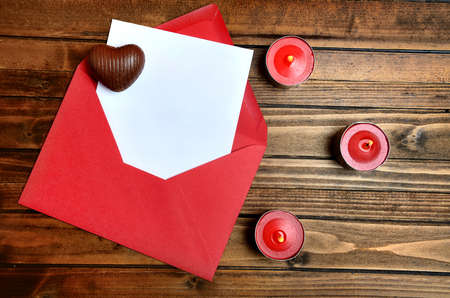 Red envelope with white paper on wooden tableの写真素材