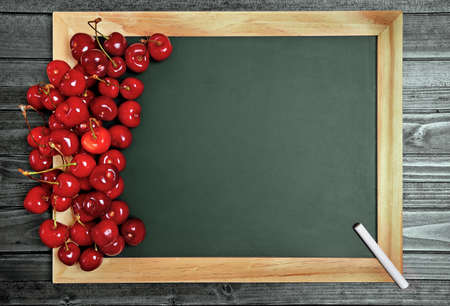 Chalkboard with cherries fruit on wooden tableの写真素材