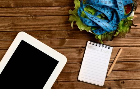 Vegetable salad with centimeter and tablet on tableの写真素材