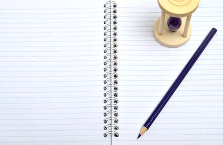 Open notebook with pencil and time glassの写真素材