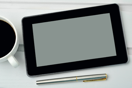 Cup of coffee with tablet pc and fountain pen on tableの写真素材