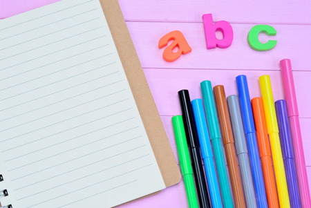 Empty notebook with colorful marker on purple wooden tableの写真素材