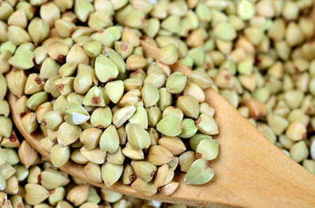 Green buckwheat in a wooden spoonの写真素材