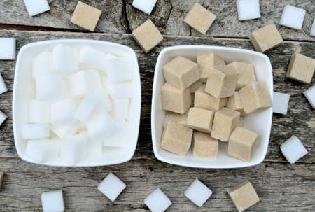 Sugar cubes in ceramic white bowl on rustic table
