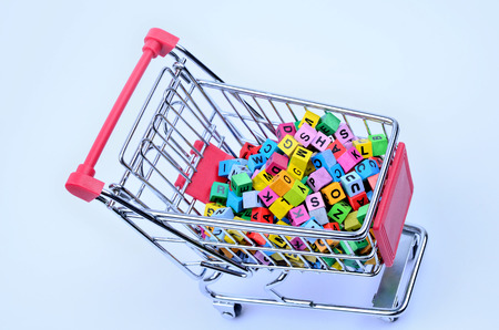 Shopping cart with wooden cubes on blue backgroundの写真素材