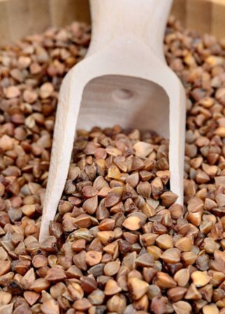 Brown buckwheat groats in a wooden scoopの写真素材