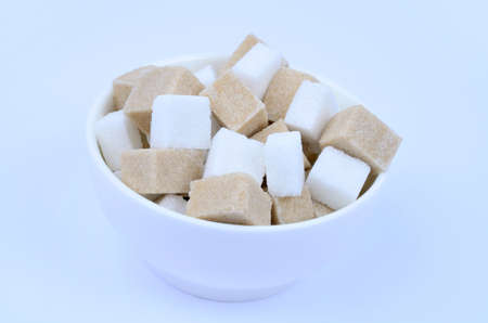 White bowl with sugar cubes on blue backgroundの写真素材