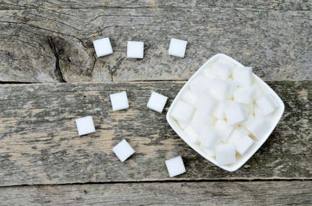 Bowl with white sugar cubes on rustic tableの写真素材