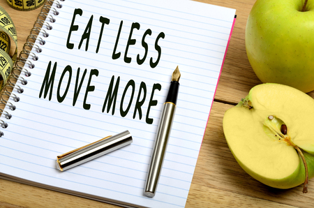 Eat less move more words on notepadの写真素材