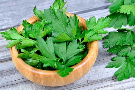 Parsley in a bamboo bowl on grey wooden tableの写真素材