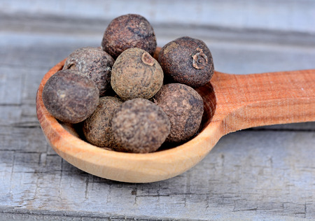 Wooden spoon with allspice on table closeupの写真素材