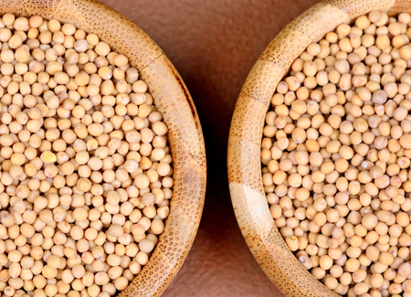 Mustard seeds in a bowls on brown background