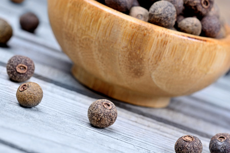Bowl with allspice on blue wooden tableの写真素材