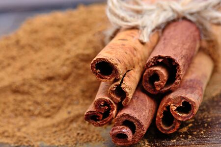 Cinnamon powder and sticks on wooden tableの写真素材