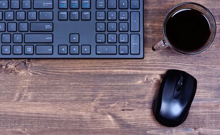 Keyboard computer with mouse and coffee cup on tableの写真素材