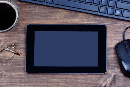 Digital tablet pc with coffee and keyboard computer on deskの写真素材