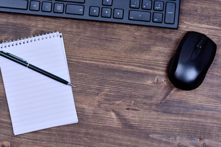 Notepad with keyboard pc and mouse on wooden table