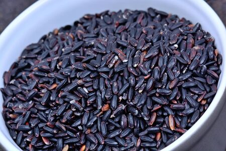 Pot with black rice on wooden tableの写真素材