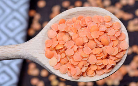 Spoon with many red lentils on tableの写真素材