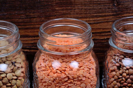 Jars with various types of lentils on wooden backgroundの写真素材