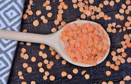 Wooden spoon with red lentils on wooden tableの写真素材