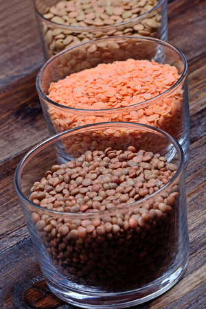 Variety types of lentils in a bowls on wooden tableの写真素材