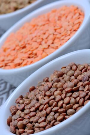 Bowls with different types of lentils on tableの写真素材
