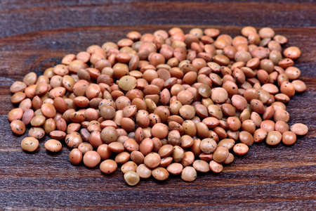 Group of brown lentils on wooden table