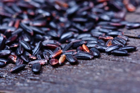 Heap of black rice on wooden tableの写真素材