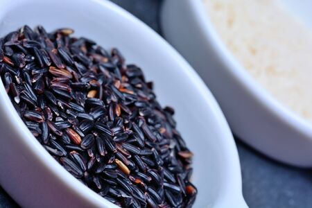 Bowls with black and white rice on slate close-upの写真素材
